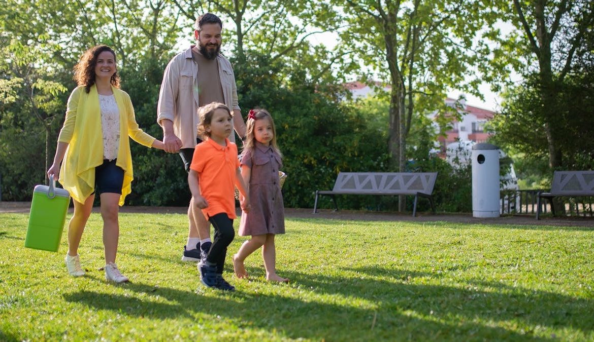 A joyful family with children strolling in a sunny Portuguese park.